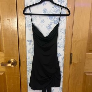 THATSSOFETCH black mini dress with a slit and an open back.
